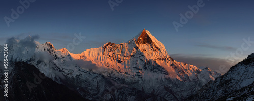 Snow capped Mt. Machapuchare colored by last rays of sun, view from Annapurna base camp. Himalaya mountains, Nepal. © Anna