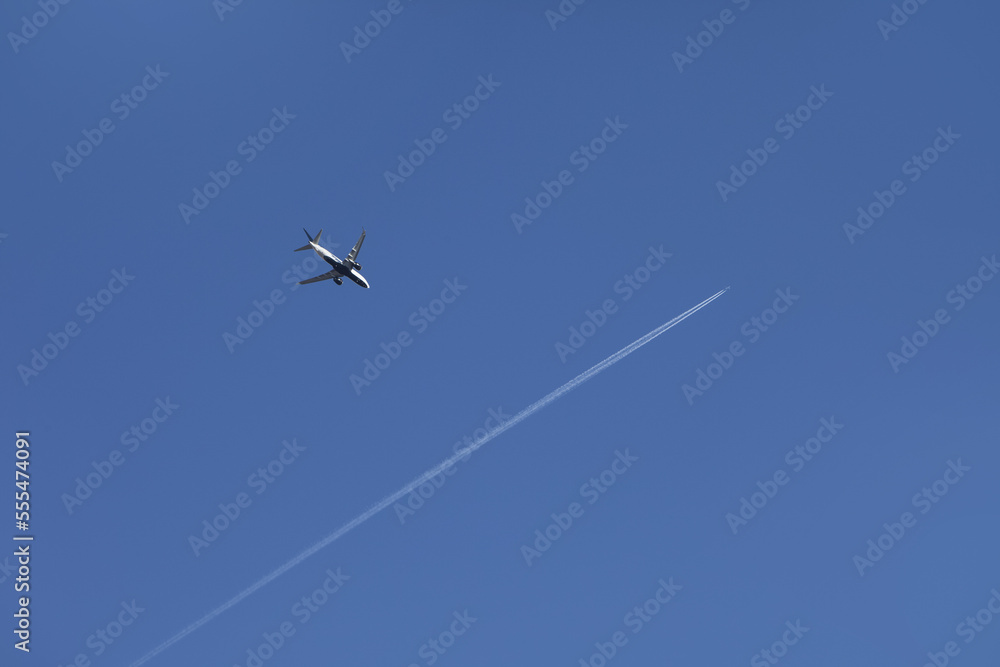 Commercial aircraft crossing paths over Halton Hills in a blue sky; Ontario, Canada Commercial aircraft crossing paths over Halton Hills in a blue sky; Ontario, Canada