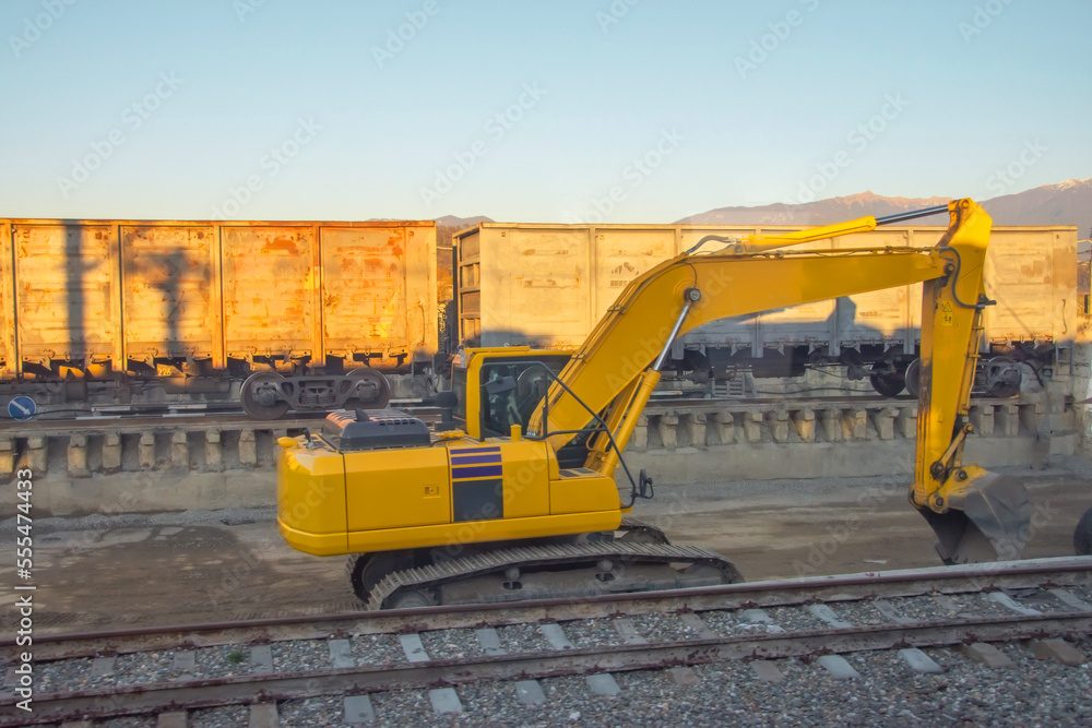 Unloading unloading rubble with an excavator wagons with bulk cargo gravel, sand at the station. Unloading unloading rubble with an excavator wagons with bulk cargo gravel, sand at the station.