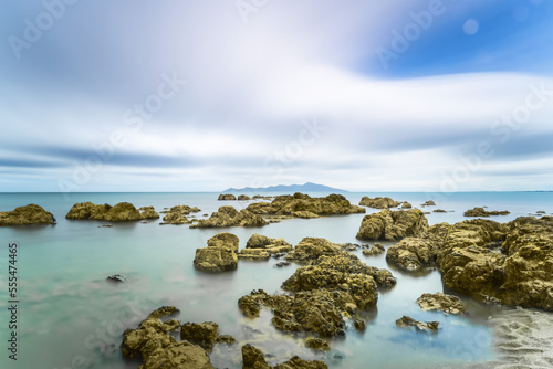 Rocks in the ocean along the shoreline in Pukerua Bay, Kapiti Island; Wellington, New Zealand photo
