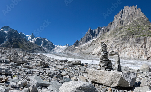 The glacial stream on the glacier Mer de Glace with the Garand Jorasses and Aigulles towers in the background. photo