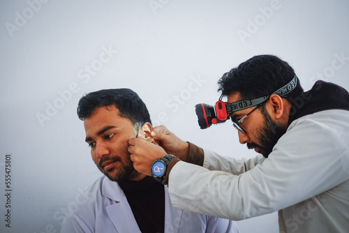 Fotografia South asian medical student practicing ent examination on each other wearing whi