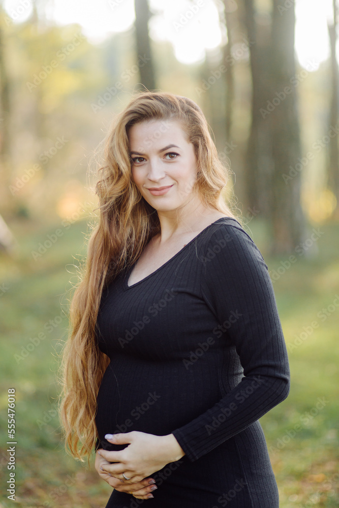 Obraz premium Pregnant happy young woman walking outdoors in forest