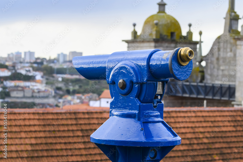 Blue binoculars looking out over a rooftop and the city of Porto; Porto, Portugal Blue binoculars looking out over a rooftop and the city of Porto; Porto, Portugal