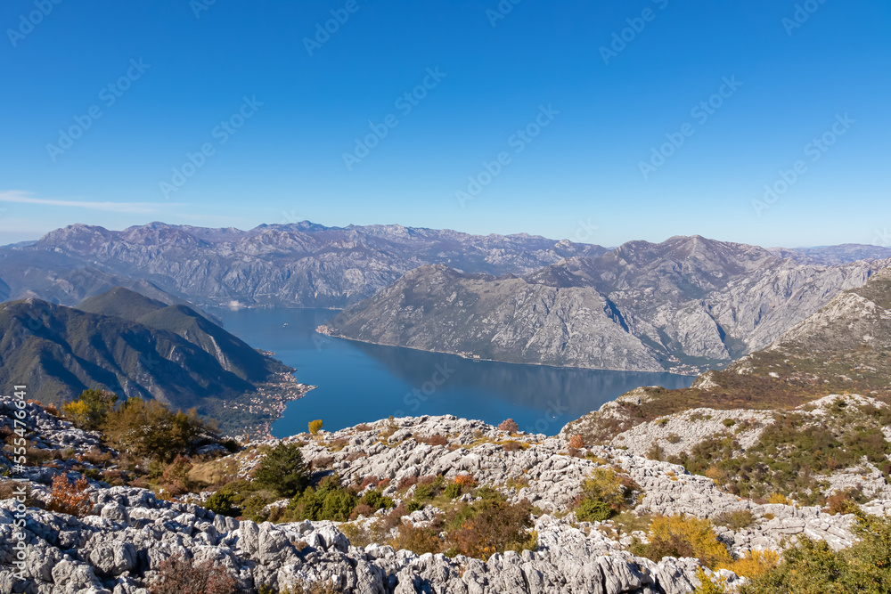 Obraz premium Panoramic view from Pestingrad (Derinski Vrh) of Kotor bay in sunny summer, Adriatic Mediterranean Sea, Montenegro, Balkan Peninsula, Europe. Fjord winding along coastal towns. Lovcen, Orjen mountains
