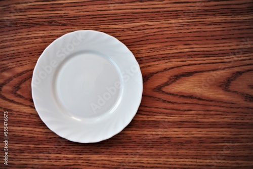 White dining plate on the table with a brown wooden pattern