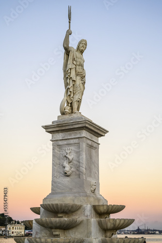 Statue of Poseidon with trident at the waterfront of the Bay of Havana at sunset; Havana, Cuba photo