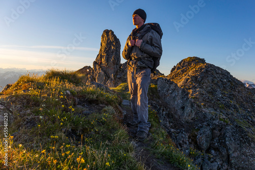 Hiker on the Pioneer Ridge-Austin Helmers Trail after sunrise; Alaska, United States of America