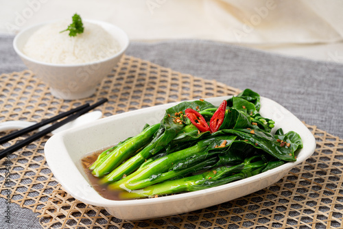 HK KAI LAN W GARLIC OYSTER SAUCE with chopsticks served in dish isolated on table top view of singapore food photo