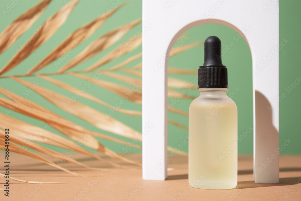 Cosmetic bottle with body and face oil on palm leaf, summer natural cosmetics, serum, facial oil, tropical concept Cosmetic bottle with body and face oil on palm leaf, summer natural cosmetics, serum, facial oil, tropical concept