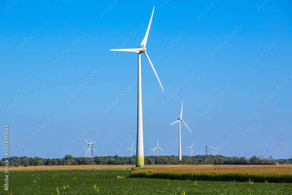 Wind turbines on farmland with a farm field in the foreground; Saint Remi, Quebec, Canada Wind turbines on farmland with a farm field in the foreground; Saint Remi, Quebec, Canada