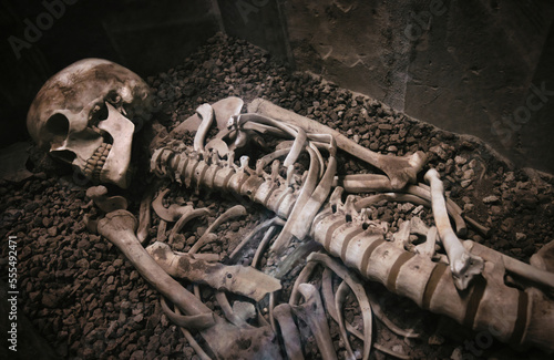 An old human skeleton lying in a stone coffin or sarcophagus