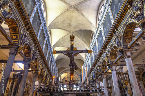 Crucifix inside a church with ornate, decorative detail on the walls and arches; Venice, Italy
