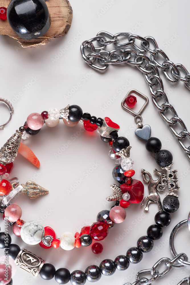 different bracelets with black and red semipreciouse stones with natural lava, shungite, hematite, rhodonite, coral and chains. top view different bracelets with black and red semipreciouse stones with natural lava, shungite, hematite, rhodonite, coral and chains. top view