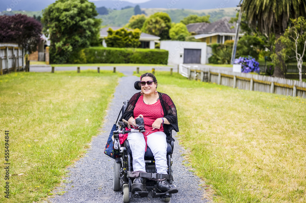 Maori woman with Cerebral Palsy in a wheelchair going down a sidewalk; Wellington, New Zealand Maori woman with Cerebral Palsy in a wheelchair going down a sidewalk; Wellington, New Zealand