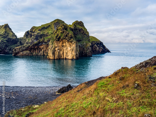 Rugged rock and cliffs along the coastline of the island of Heimaey, a part of an archipelago along the Southern coast of Iceland; Vestmannaeyjar, Southern Region, Iceland photo