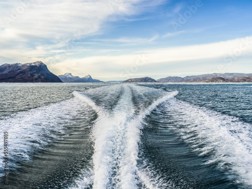 Wake behind a boat along the coastline of Sermersooq; Sermersooq, Greenland