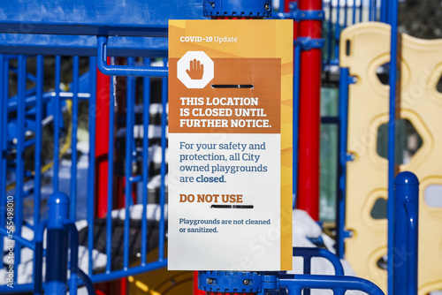 A sign at a playground cordoned off with caution tape during the COVID-19 World Pandemic; Edmonton, Alberta, Canada photo