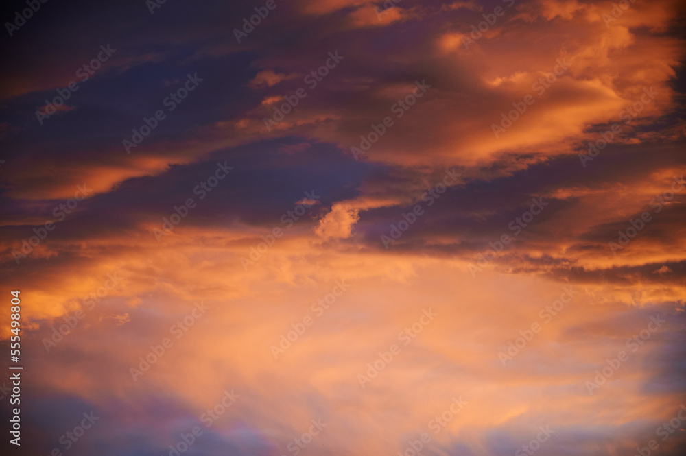 Sunrise with a sky loaded with beautiful clouds with blue and orange colors forming a swirl