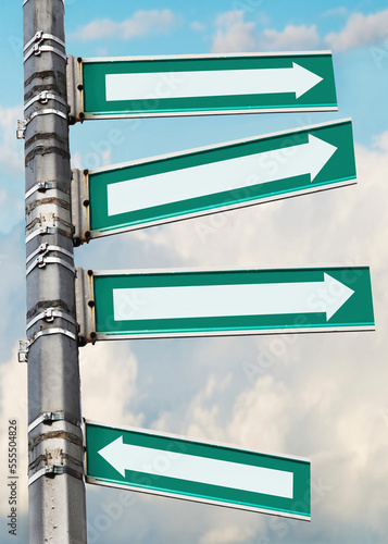 Arrow signs on a pole, showing different directions against sky photo