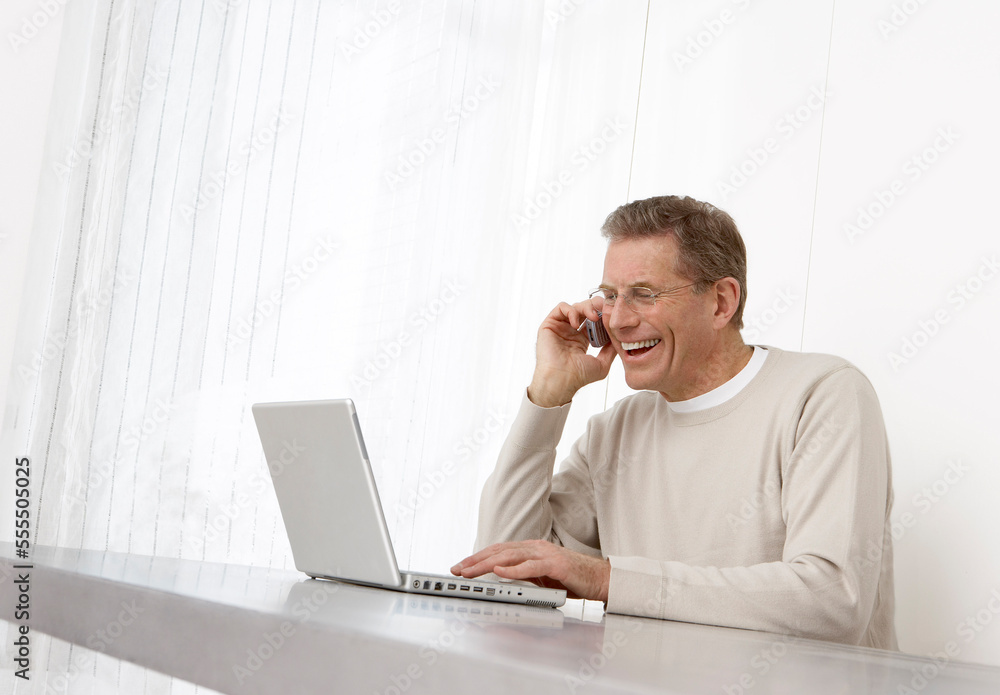 Man Using Laptop and Cell Phone Man Using Laptop and Cell Phone
