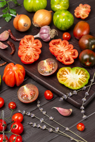 Tomatoes of different varieties on cutting board.