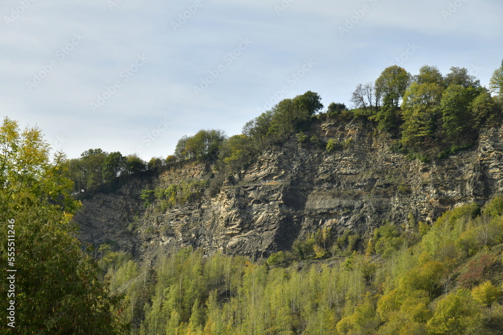 Les pans de rochers en granit gris issues des anciennes carrières couvertes de végétation luxuriante ,dominant la forêt et la vallée de l'Amblève à Aywaille 