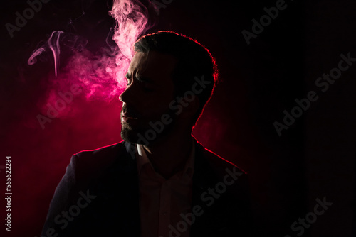 Photo of smoking man on pink background. © Andrii