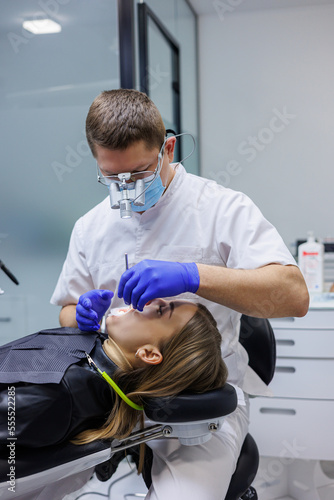 A dentist treats a patient s teeth. Modern progressive dentistry. Dental office with tools.