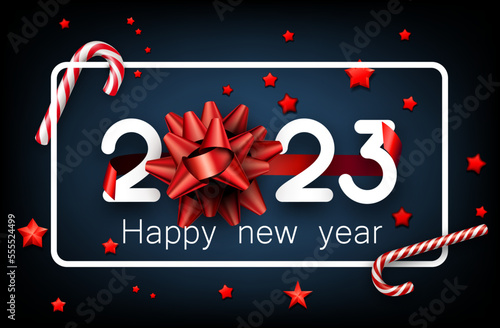 2023 sign with red bow, candy canes, stars confetti on blue background.