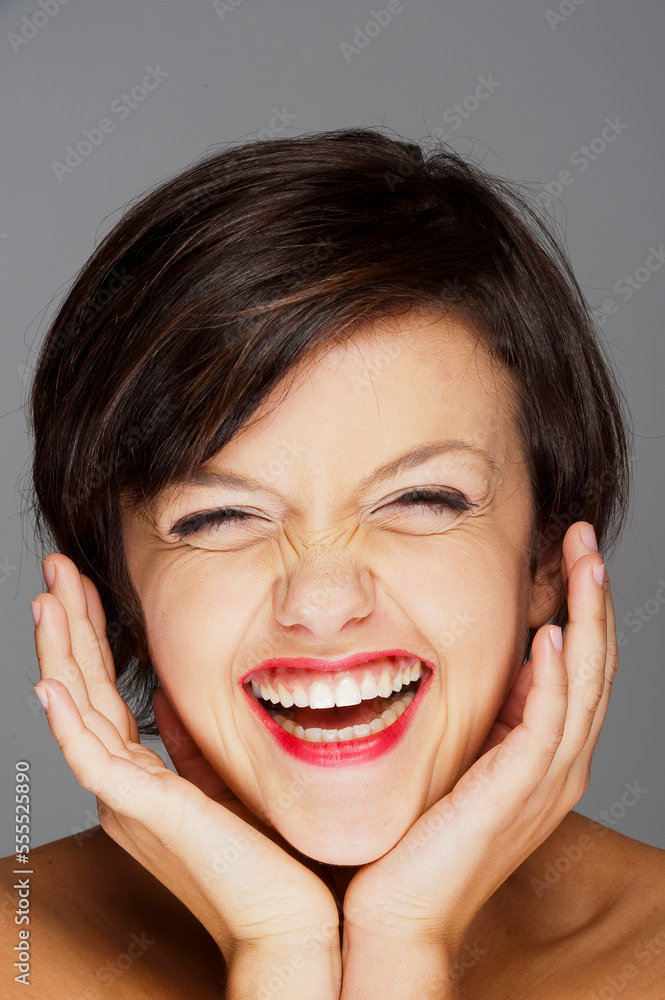 Head and Shoulders Portrait of Mid-Adult Woman Laughing with Grey Background Head and Shoulders Portrait of Mid-Adult Woman Laughing with Grey Background