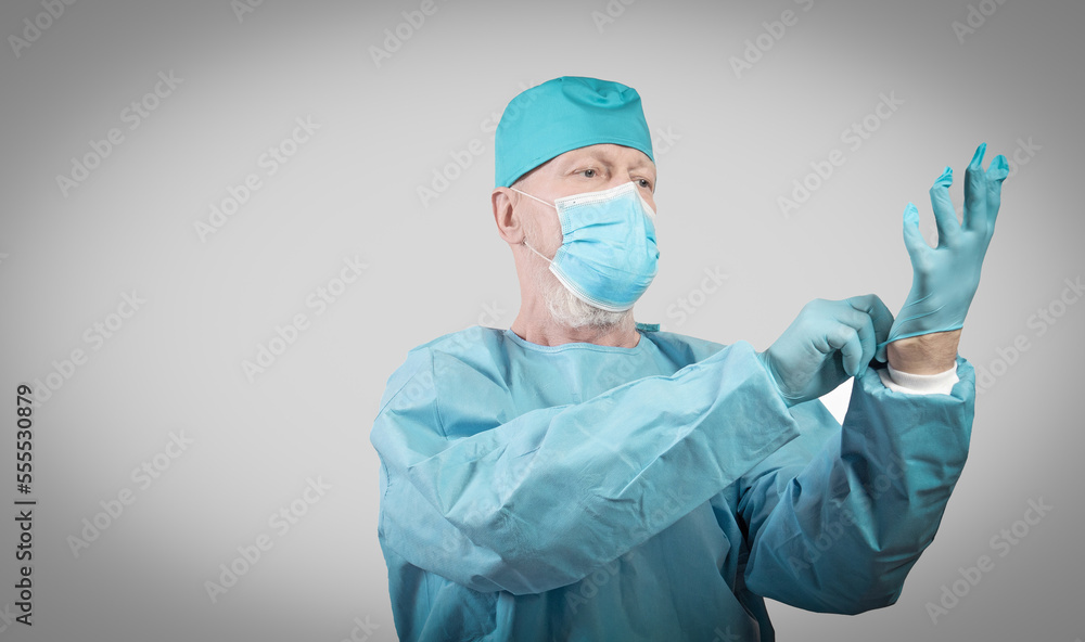 Infectious disease doctor in protective overalls and a mask puts on protective gloves Infectious disease doctor in protective overalls and a mask puts on protective gloves