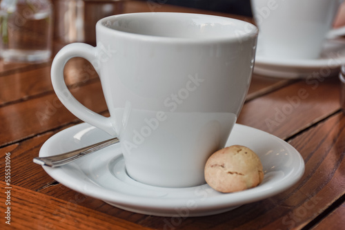  a cup of espresso coffee served with a cookie on wooden table. Vintage, romantic coffee concept