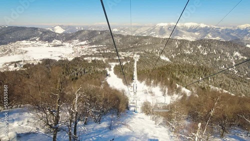 Aerial passengers point of view from chairlift going up in winter Bakuriani ski resort in Georgia. Famous travel destination for outdoors skiing photo