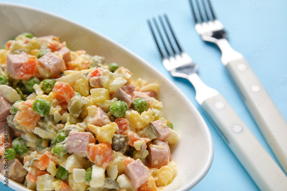 Bowl of tasty Olivier salad on color background, closeup Bowl of tasty Olivier salad on color background, closeup