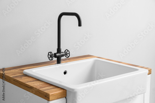 Table with ceramic sink near light wall