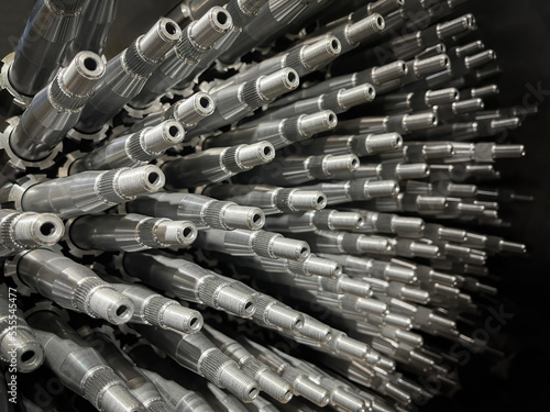 set of machined steel shafts stacked, spare parts of steering columns, selective focus, metalworking, automotive parts industry © Javier