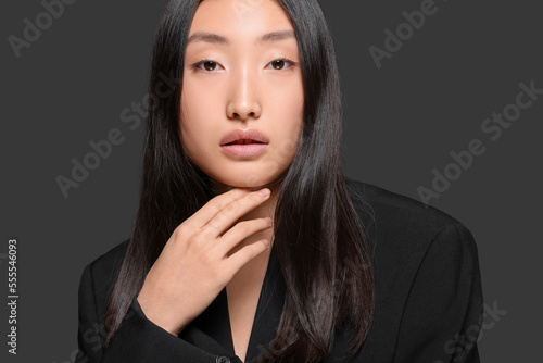 Portrait of beautiful young Asian woman on black background