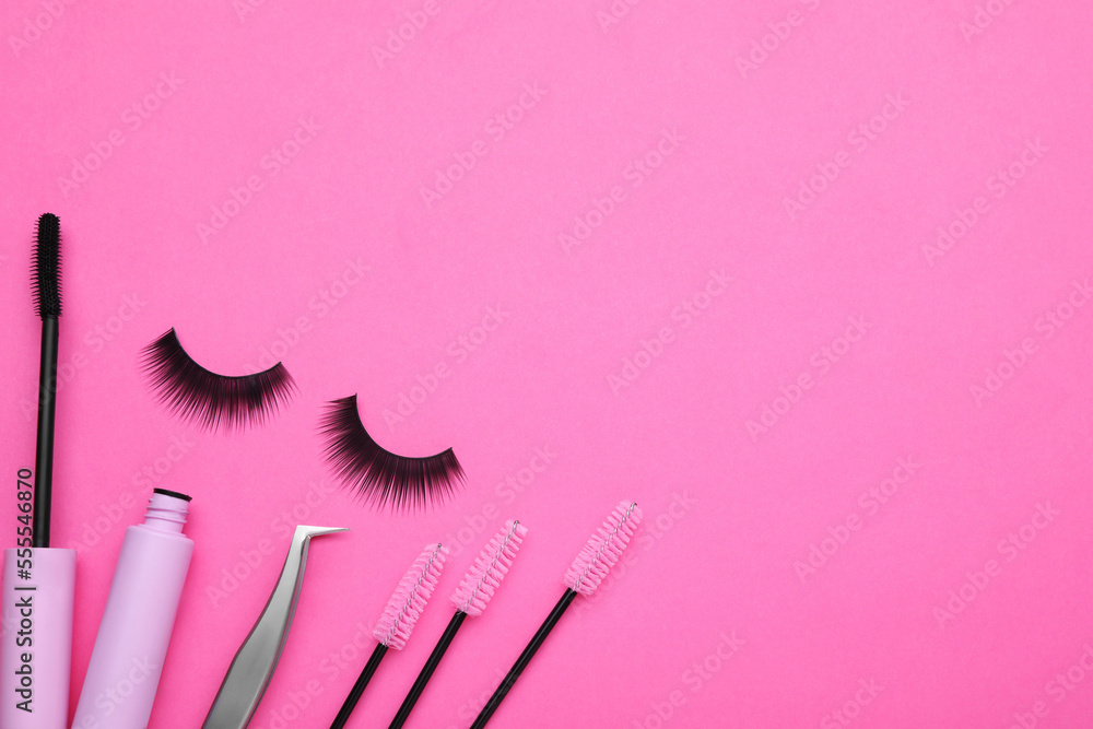 Fake eyelashes, brushes and tweezers on pink background, flat lay. Space for text Fake eyelashes, brushes and tweezers on pink background, flat lay. Space for text
