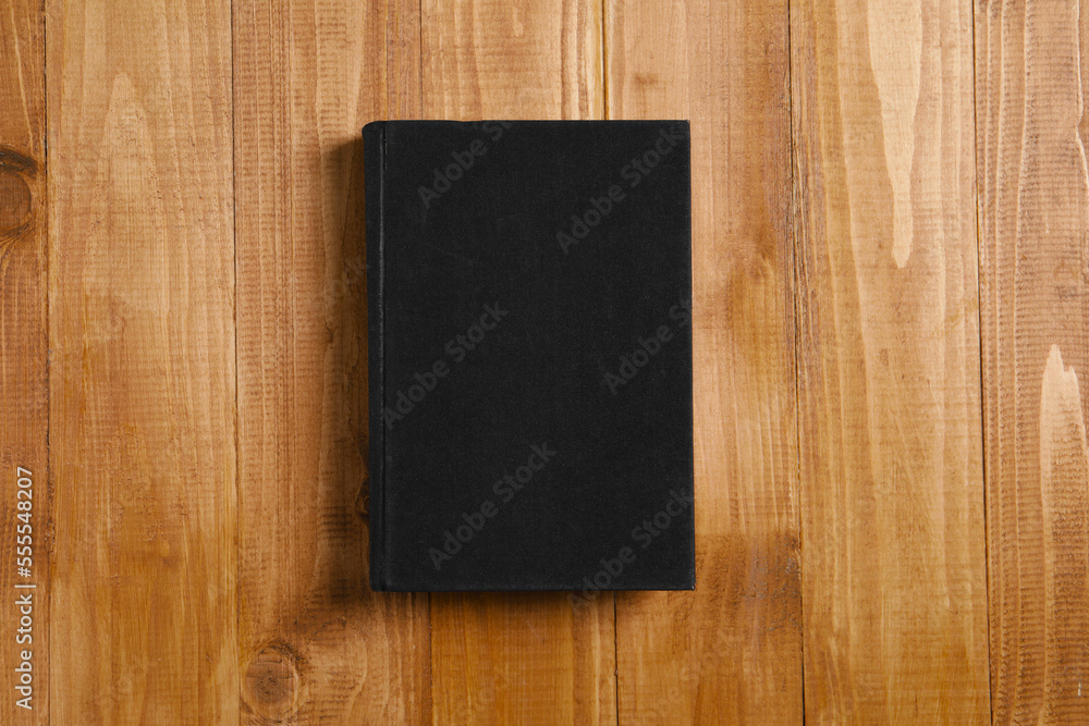 Old hardcover book on wooden table, top view Old hardcover book on wooden table, top view