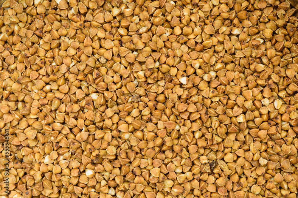 Texture of buckwheat. Detailed photo of spilled buckwheat, raw vegetarian food Texture of buckwheat. Detailed photo of spilled buckwheat, raw vegetarian food