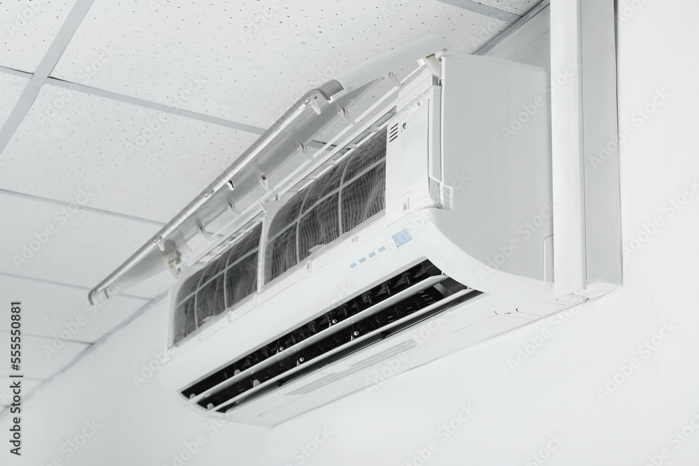 Modern air conditioner hanging on white wall Modern air conditioner hanging on white wall