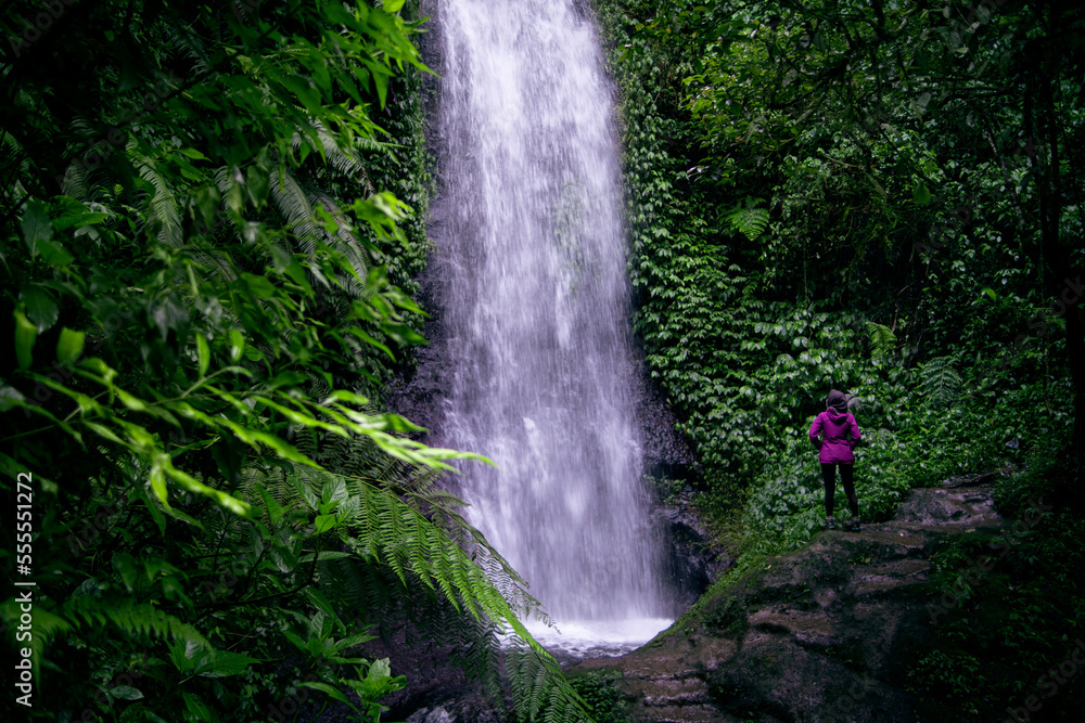 young women wearing hijab standing backwards and observing the forest and the river young women wearing hijab standing backwards and observing the forest and the river