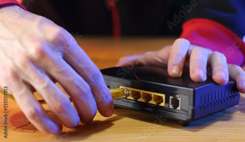 Obraz na płótnie connecting internet cable to old adsl modem on table
