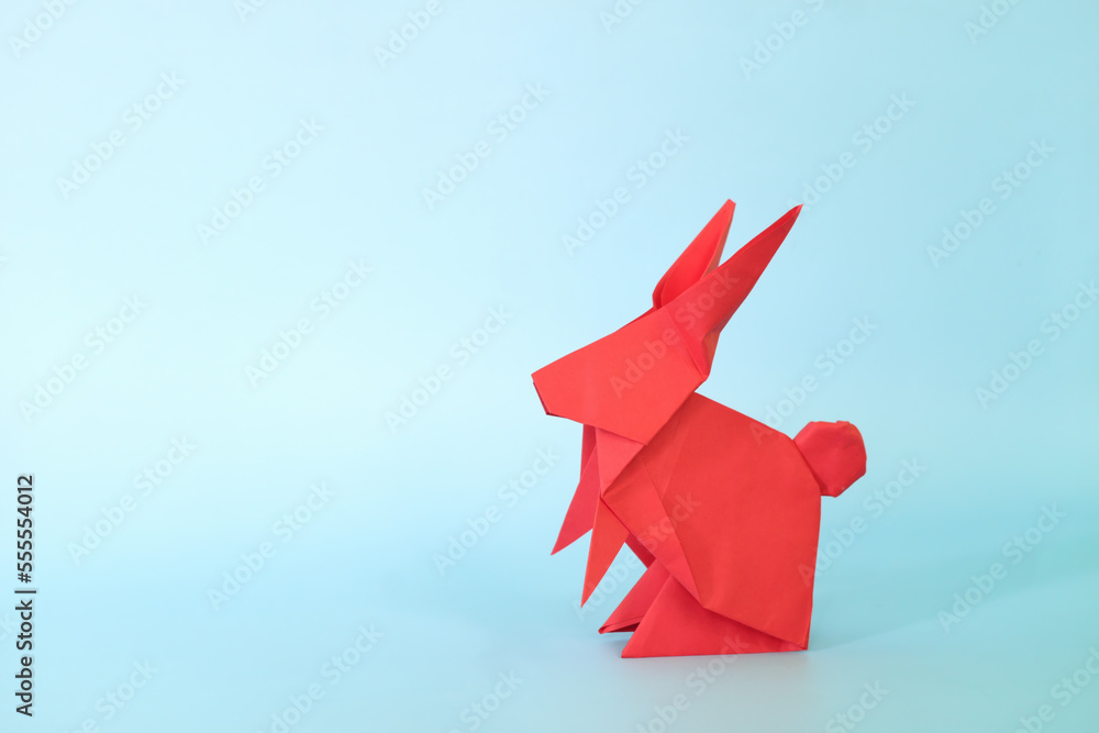 Red rabbit or bunny origami isolated in blue background. Chinese new year of the rabbit and easter celebration concept.