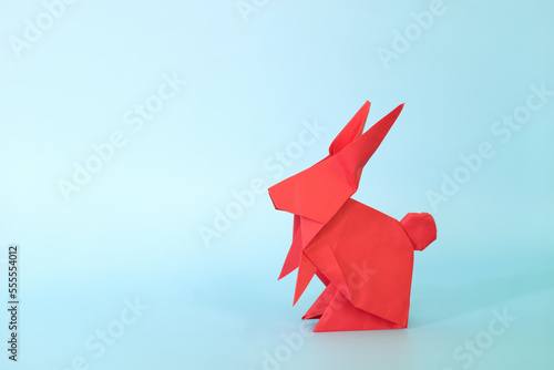 Obraz na płótnie Red rabbit or bunny origami isolated in blue background. Chinese new year of the rabbit and easter celebration concept. w salonie