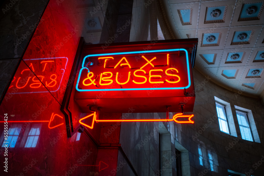 Φωτογραφία Bright vibrant red and blue city urban neon sign with arrow pointing to taxi and