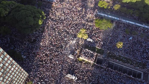 Multitude of people celebrating in 9th July Avenue around obelisk the final victory of soccer World Cup 2022, Buenos Aires. Aerial drone top-down view photo