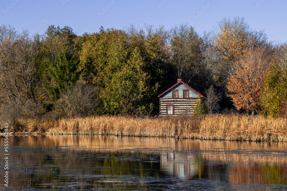 old log house reflected in a river