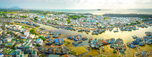 La Gi fishing village seen from above with hundreds of boats anchored along both sides of river to avoid storms near estuary, this is also a large fishing port providing seafood in central Vietnam © huythoai